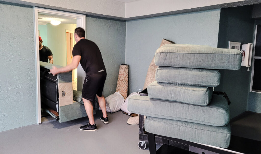 two movers moving a couch into an elevvator