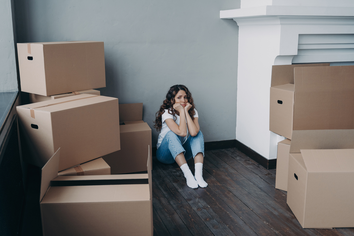 girl trying to handle her emotions surrounded by moving boxes