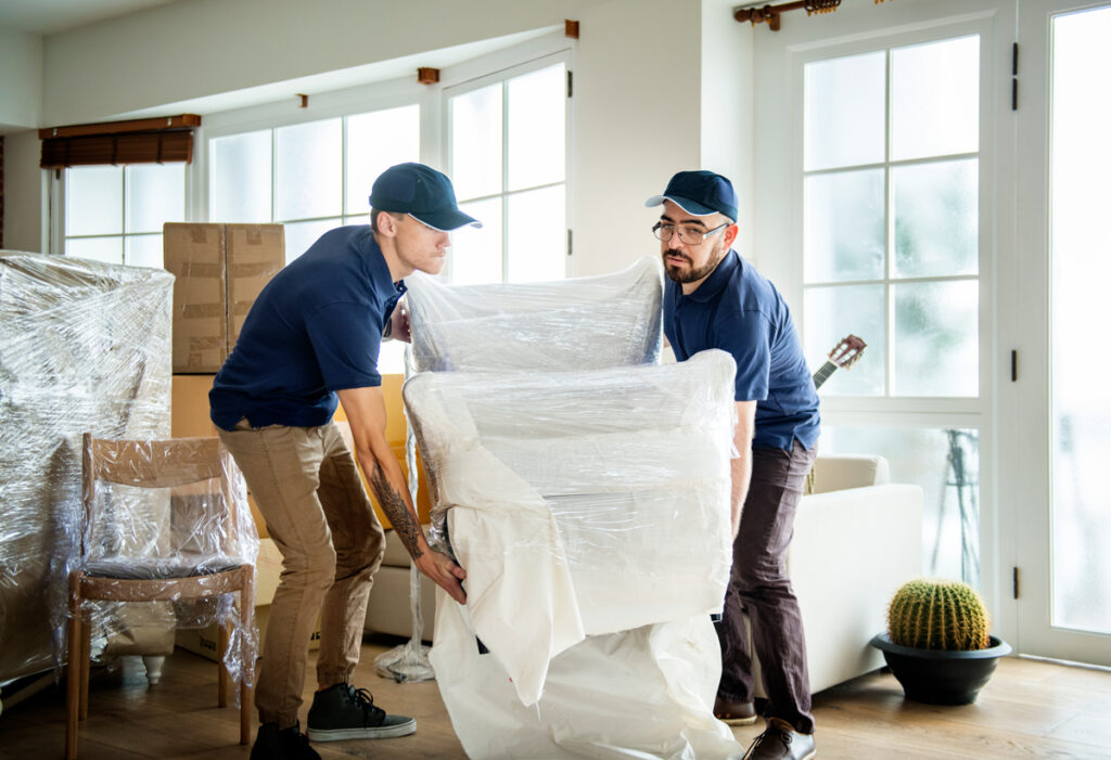 two men lifting a shrink wrapped chair